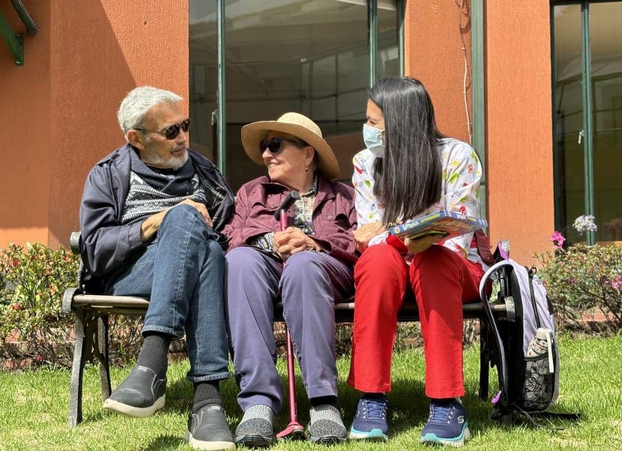 Pareja de personas mayor junto con enfermera o terapeuta